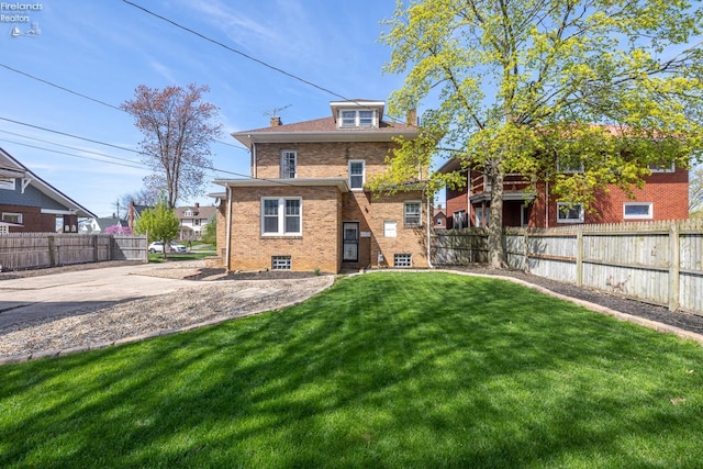 1507 S Lakeview Blvd, Lorain, OH 44052 - back of house with a lawn, fence, brick siding, and a chimney