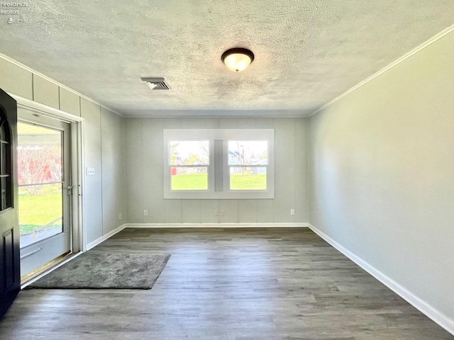 120 Mckim St, Bellevue, OH 44811 - empty room featuring ornamental molding, a textured ceiling, baseboards, and dark wood finished floors