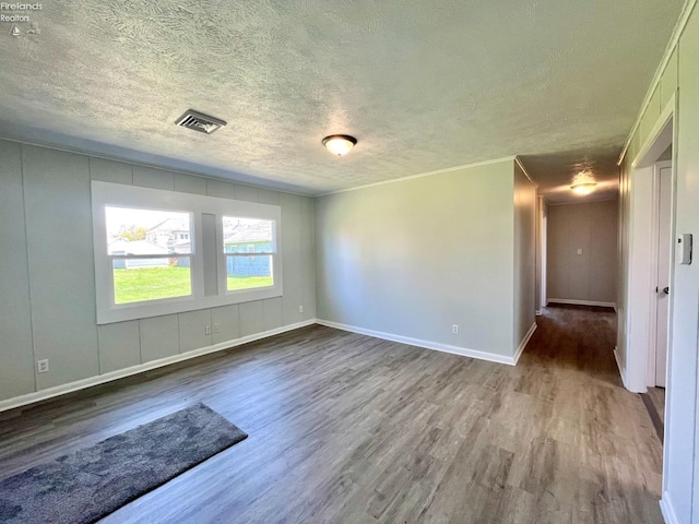 120 Mckim St, Bellevue, OH 44811 - empty room with a textured ceiling, wood finished floors, visible vents, and baseboards