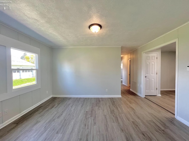 120 Mckim St, Bellevue, OH 44811 - empty room featuring baseboards, wood finished floors, and a textured ceiling