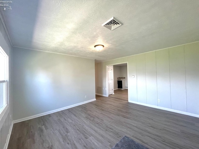 120 Mckim St, Bellevue, OH 44811 - unfurnished room with a textured ceiling, visible vents, dark wood-style flooring, and baseboards