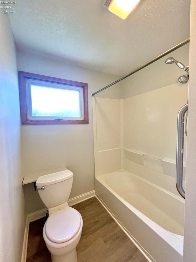 120 Mckim St, Bellevue, OH 44811 - bathroom featuring a textured ceiling, baseboards, toilet, shower / bathing tub combination, and wood finished floors