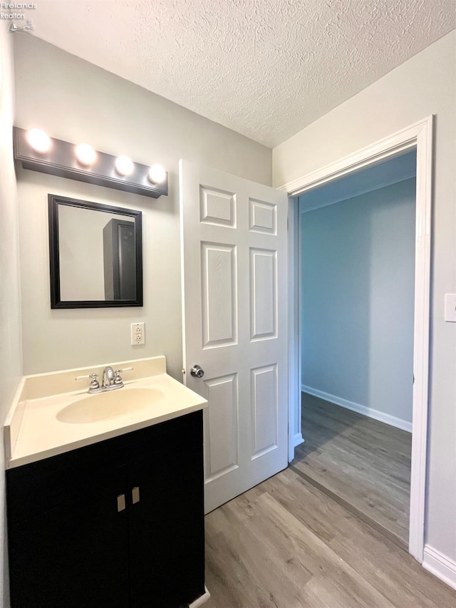 120 Mckim St, Bellevue, OH 44811 - bathroom with baseboards, wood finished floors, a textured ceiling, and vanity