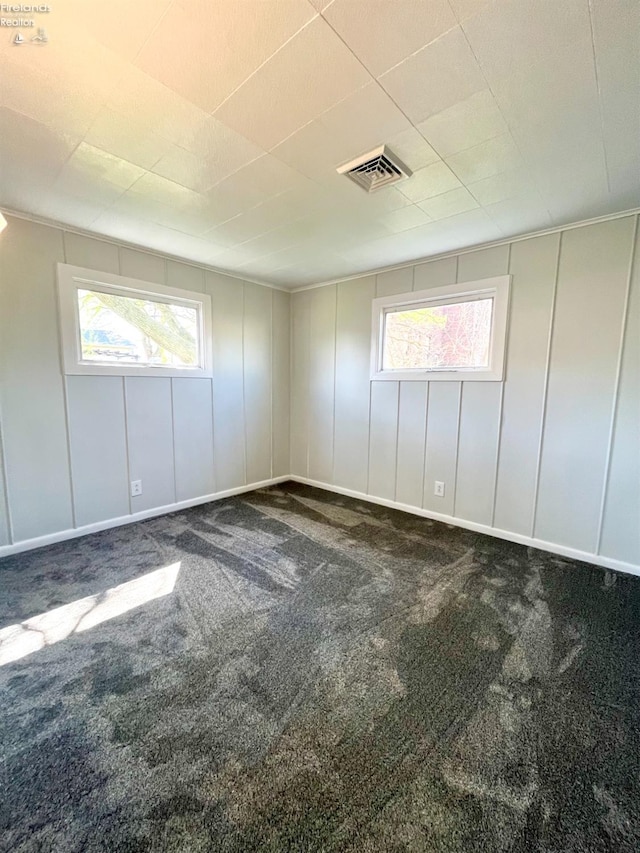 120 Mckim St, Bellevue, OH 44811 - carpeted empty room with visible vents, a wealth of natural light, and a decorative wall