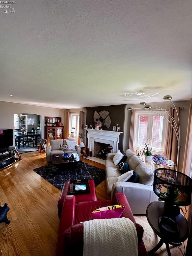 5106 Ottawa River Rd, Toledo, OH 43611 - living room featuring a textured ceiling, a fireplace with flush hearth, and wood finished floors