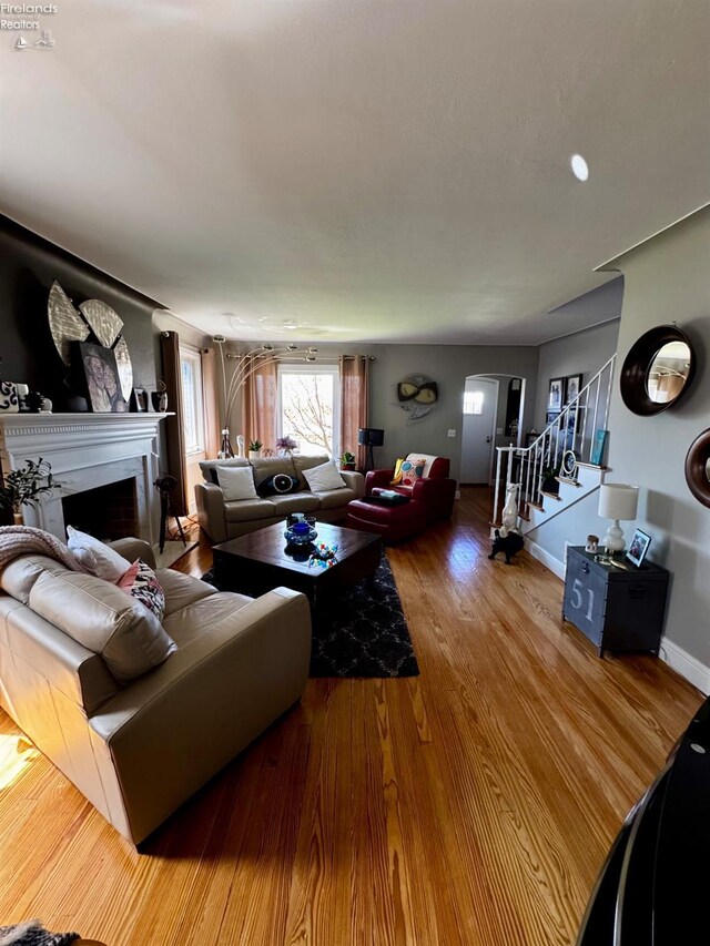 5106 Ottawa River Rd, Toledo, OH 43611 - living area with stairway, a fireplace, baseboards, arched walkways, and wood finished floors