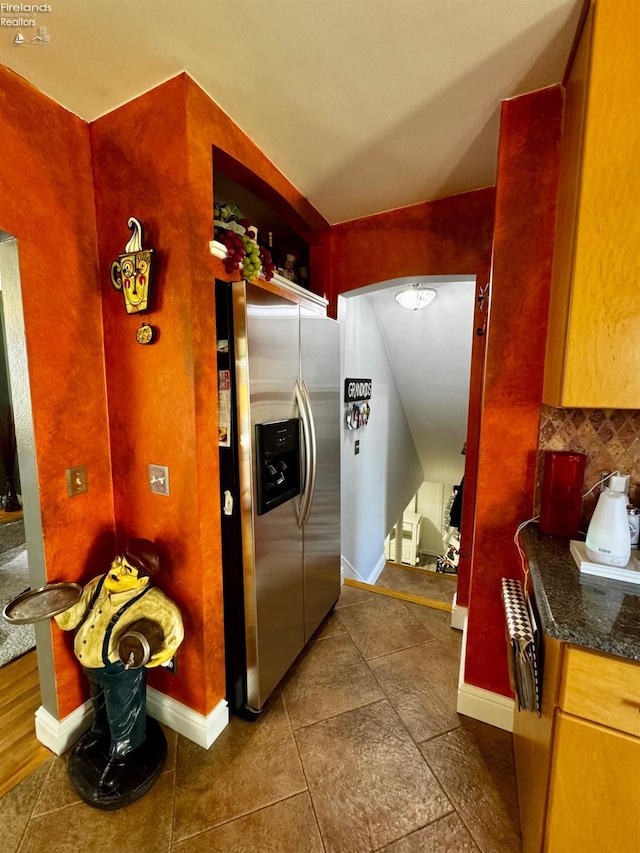 5106 Ottawa River Rd, Toledo, OH 43611 - kitchen with arched walkways, dark tile patterned flooring, stainless steel fridge with ice dispenser, dark countertops, and baseboards