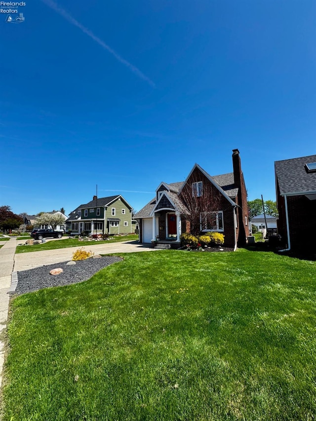 5106 Ottawa River Rd, Toledo, OH 43611 - view of front facade with driveway, a chimney, a front yard, and a garage