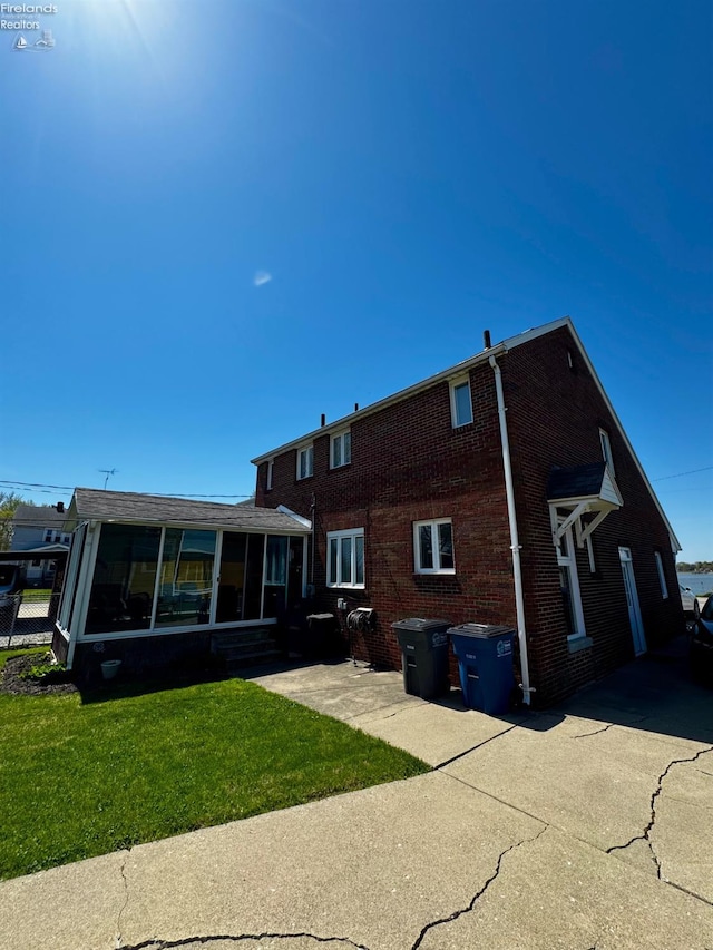 5106 Ottawa River Rd, Toledo, OH 43611 - back of property with brick siding, a yard, and a sunroom