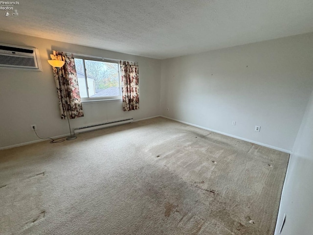 carpeted spare room featuring a baseboard heating unit, a textured ceiling, a wall mounted air conditioner, and baseboards