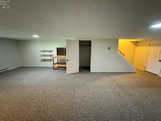 finished below grade area featuring a textured ceiling, carpet flooring, stairway, and baseboards