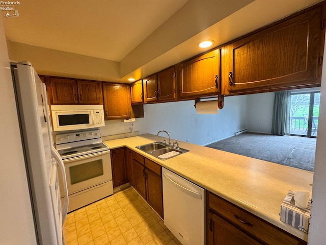 kitchen with white appliances, light countertops, baseboard heating, light carpet, and a sink