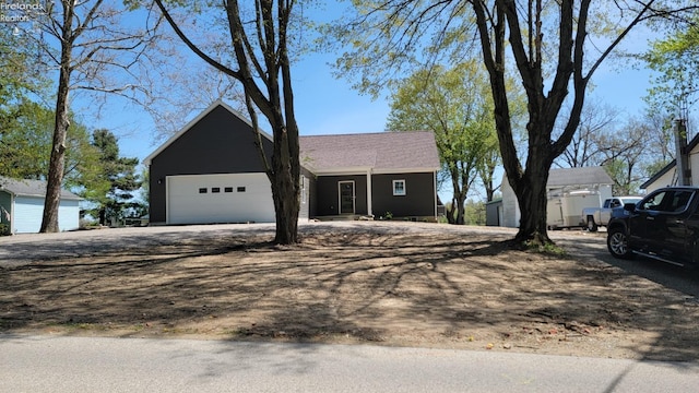 ranch-style house with a garage and dirt driveway