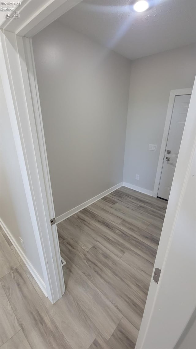 empty room featuring wood finished floors and baseboards