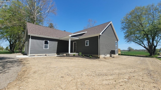 view of front of property featuring a shingled roof, driveway, and central AC unit