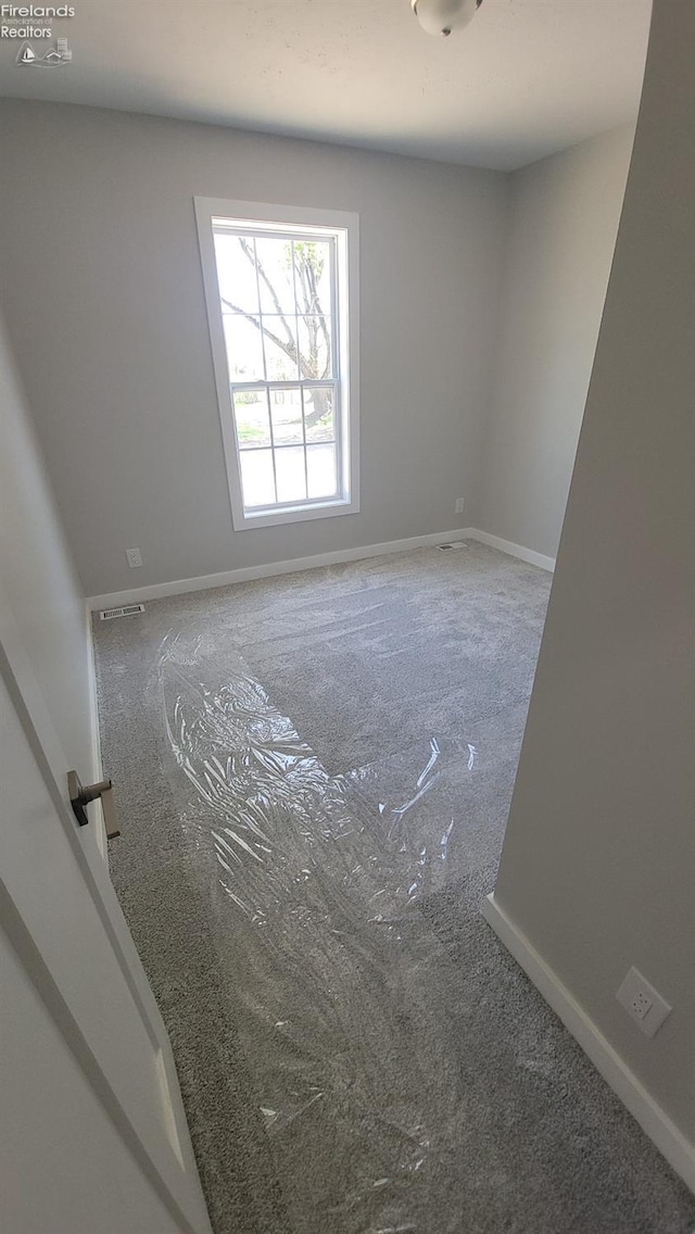 empty room with carpet floors and baseboards
