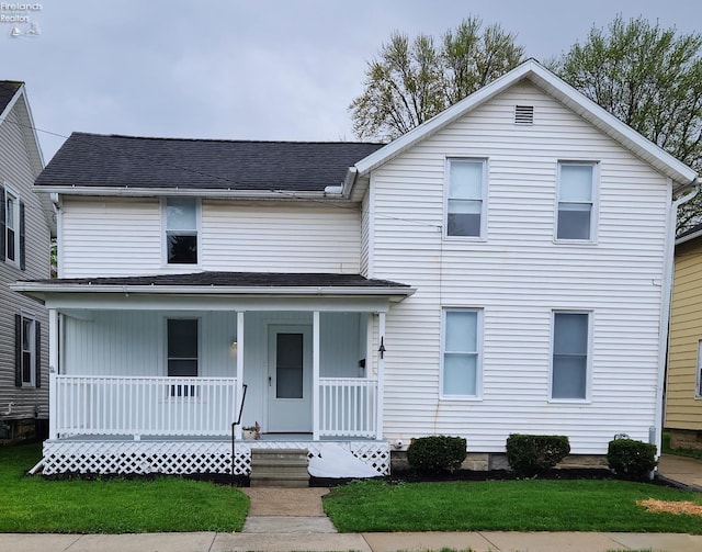 traditional home with covered porch and roof with shingles