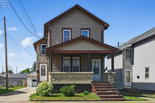 traditional home with covered porch and a detached garage