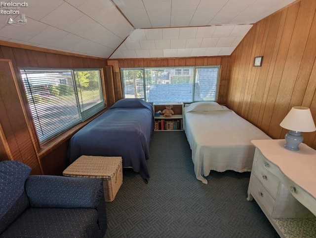 bedroom with wooden walls, multiple windows, lofted ceiling, and dark colored carpet