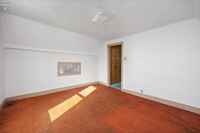additional living space featuring carpet floors, baseboards, and lofted ceiling