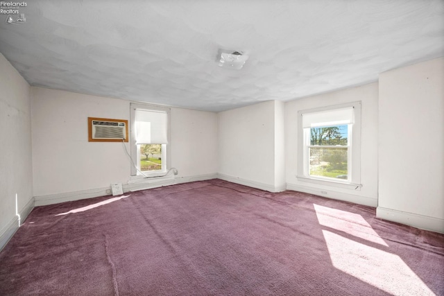 unfurnished room featuring baseboards, carpet, and a wall mounted air conditioner
