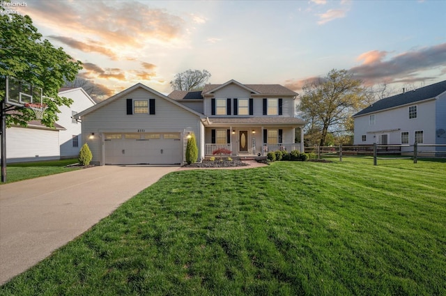 traditional-style home featuring an attached garage, fence, a front yard, concrete driveway, and a porch