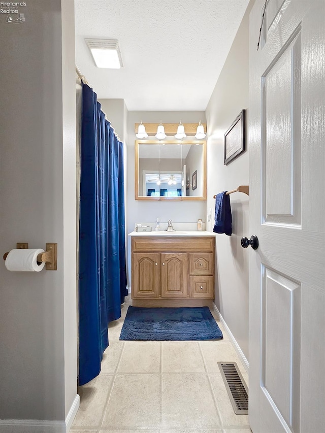 173 Excalibur Dr, Clyde, OH 43410 - bathroom featuring baseboards, vanity, a textured ceiling, and tile patterned flooring