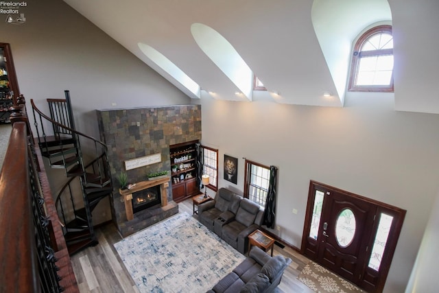 9117 W Mason Rd, Castalia, OH 44824 - living room with high vaulted ceiling, wood finished floors, a skylight, and a glass covered fireplace