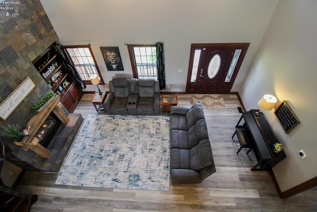 9117 W Mason Rd, Castalia, OH 44824 - living area with wood finished floors, baseboards, a tiled fireplace, and a towering ceiling