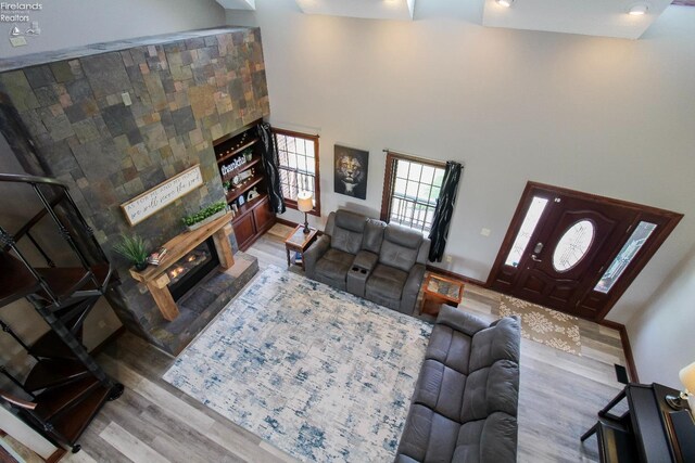9117 W Mason Rd, Castalia, OH 44824 - living area featuring a glass covered fireplace, wood finished floors, and a towering ceiling