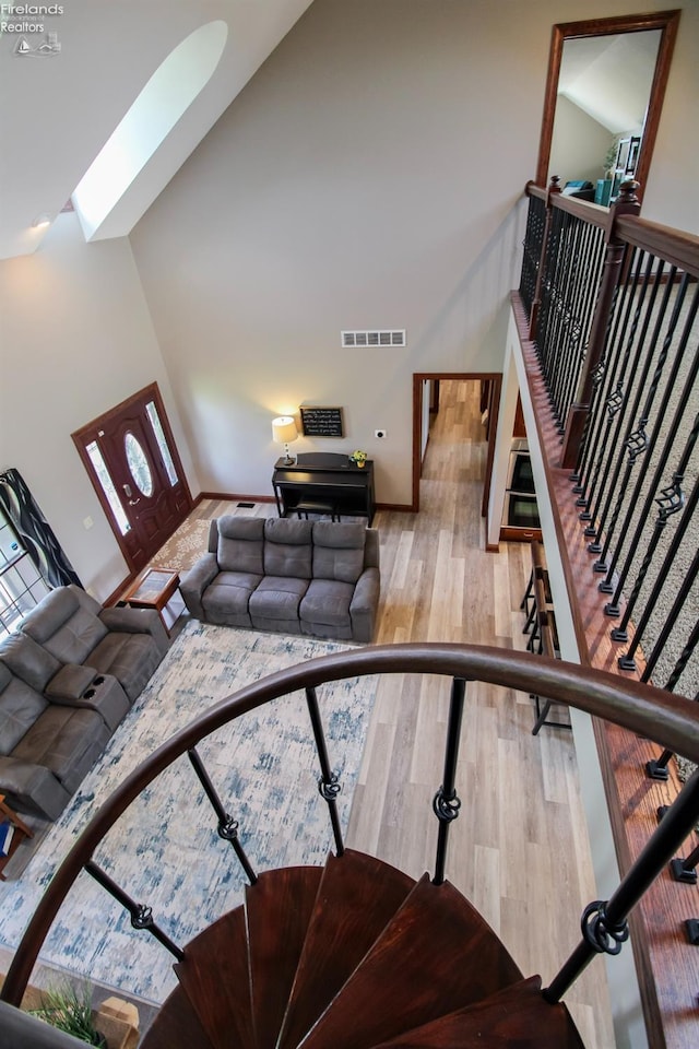 9117 W Mason Rd, Castalia, OH 44824 - living room featuring wood finished floors, a high ceiling, and a skylight