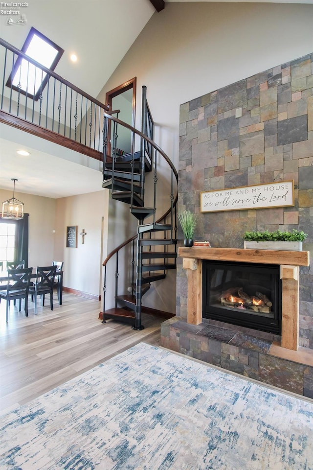 9117 W Mason Rd, Castalia, OH 44824 - stairway with high vaulted ceiling, wood finished floors, a glass covered fireplace, baseboards, and recessed lighting