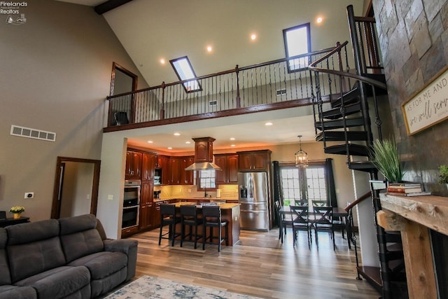 9117 W Mason Rd, Castalia, OH 44824 - living area featuring high vaulted ceiling, light wood-style floors, beam ceiling, recessed lighting, and stairs