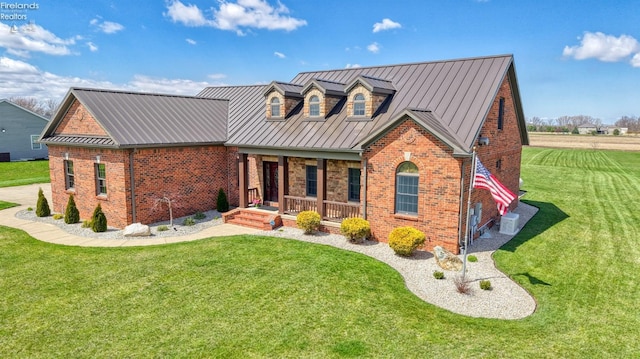 9117 W Mason Rd, Castalia, OH 44824 - view of front of property featuring covered porch, brick siding, a front yard, and metal roof