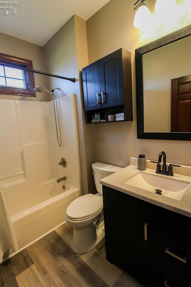 9117 W Mason Rd, Castalia, OH 44824 - bathroom with wood finished floors, toilet, vanity, and shower / washtub combination