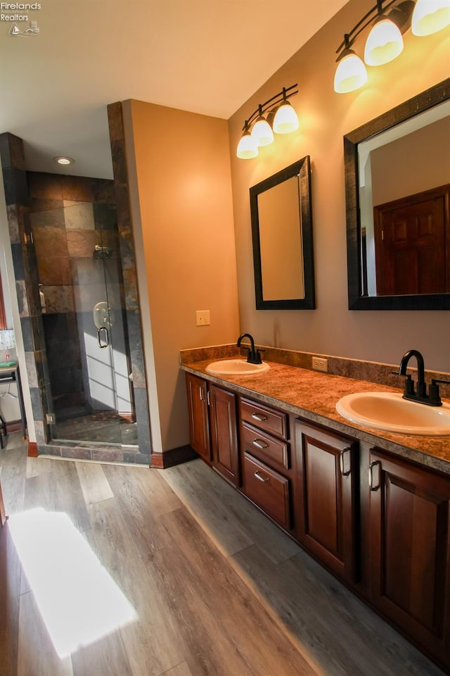 9117 W Mason Rd, Castalia, OH 44824 - full bathroom featuring wood finished floors, a shower stall, double vanity, and baseboards