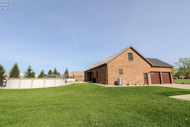 9117 W Mason Rd, Castalia, OH 44824 - view of property exterior featuring brick siding, a yard, driveway, an attached garage, and central AC