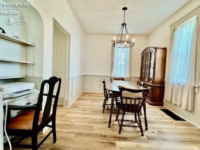 1026 Claremont Ave, Ashland, OH 44805 - dining area featuring light wood-style flooring, a chandelier, and a wainscoted wall