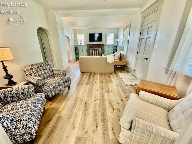 1026 Claremont Ave, Ashland, OH 44805 - living area with wood finished floors, arched walkways, baseboards, and a brick fireplace
