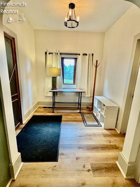 1026 Claremont Ave, Ashland, OH 44805 - corridor featuring wood finished floors, arched walkways, baseboards, and a chandelier