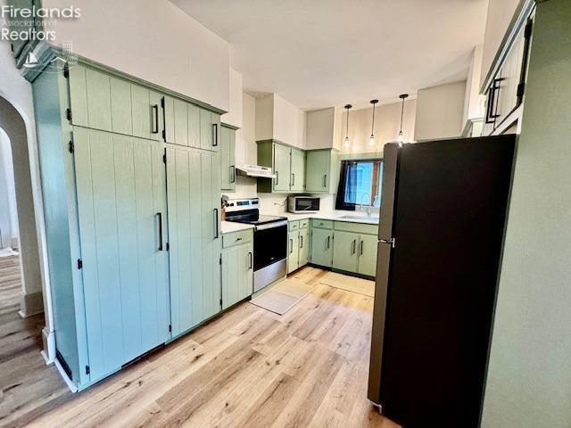 1026 Claremont Ave, Ashland, OH 44805 - kitchen with appliances with stainless steel finishes, green cabinets, a sink, light wood-style floors, and light countertops