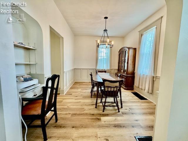 1026 Claremont Ave, Ashland, OH 44805 - dining area with a chandelier, light wood-style floors, and a wainscoted wall
