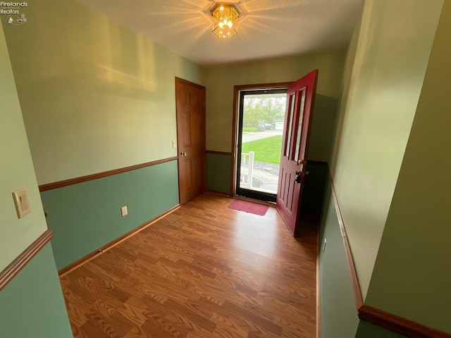 doorway featuring baseboards and light wood finished floors