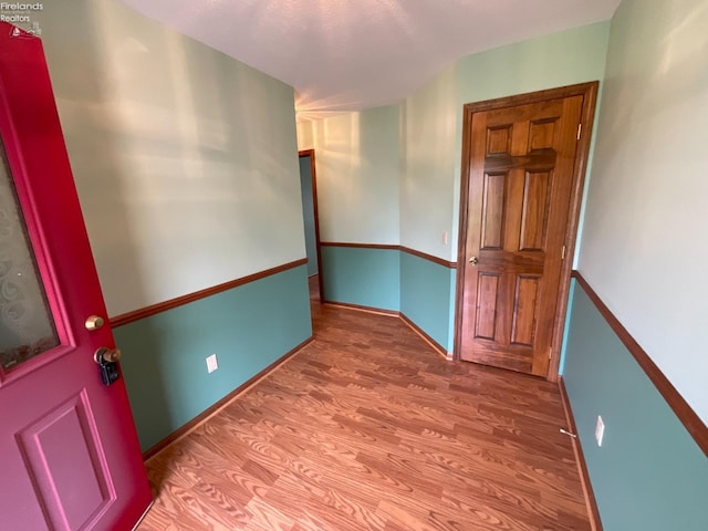 unfurnished room with baseboards and wood finished floors