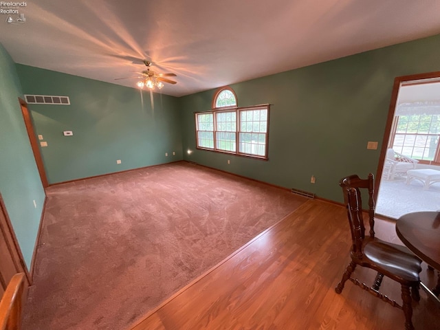 unfurnished dining area featuring visible vents, wood finished floors, and a ceiling fan