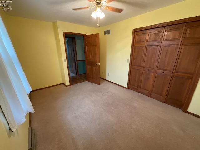 unfurnished bedroom with light colored carpet, a closet, visible vents, and baseboards