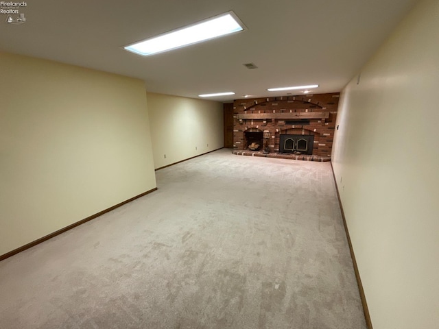 finished basement featuring baseboards, carpet flooring, and a brick fireplace