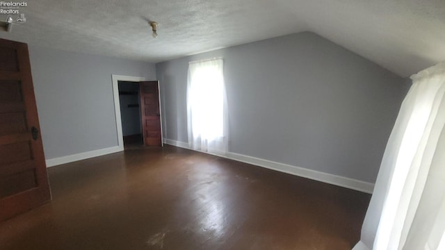 bonus room with baseboards, a textured ceiling, dark wood-style flooring, and vaulted ceiling