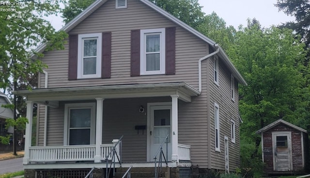 view of front of home with a porch, an outbuilding, and a storage shed