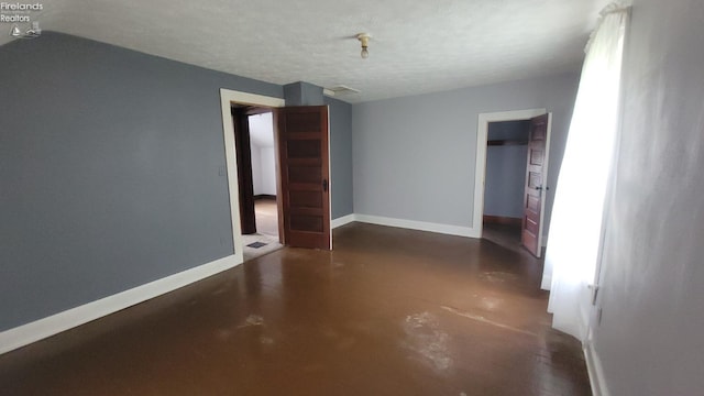 unfurnished room featuring baseboards and concrete floors